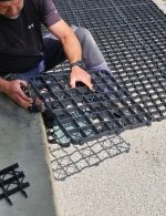 pracovník upravuje reze plastový zatrávňovač počas montáže