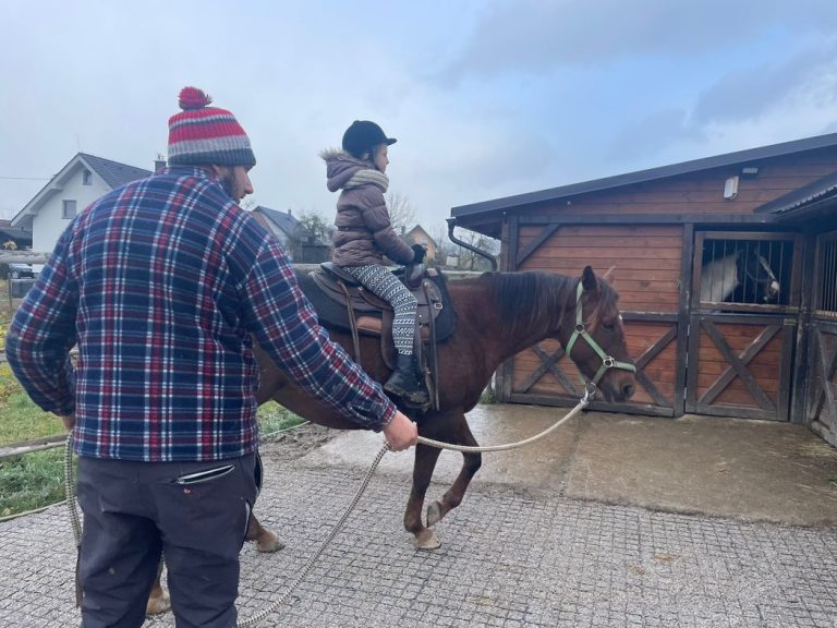 chlap drží kona na ktorom jazdí dieta na farme