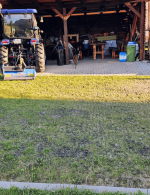 Malotraktor v garáži a pred ňou plastový zatrávňovač z ktorého je spevnené parkovisko