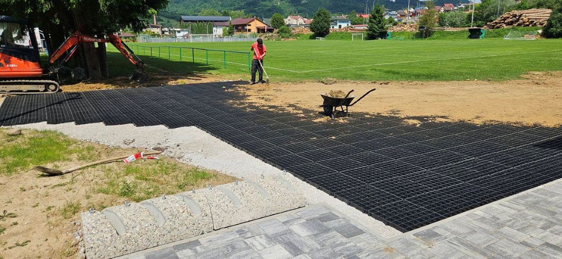 pracovník počas inštalácie vodopriepustnej zatrávňovacej dlažby na pakovisku v oddychovom areáli