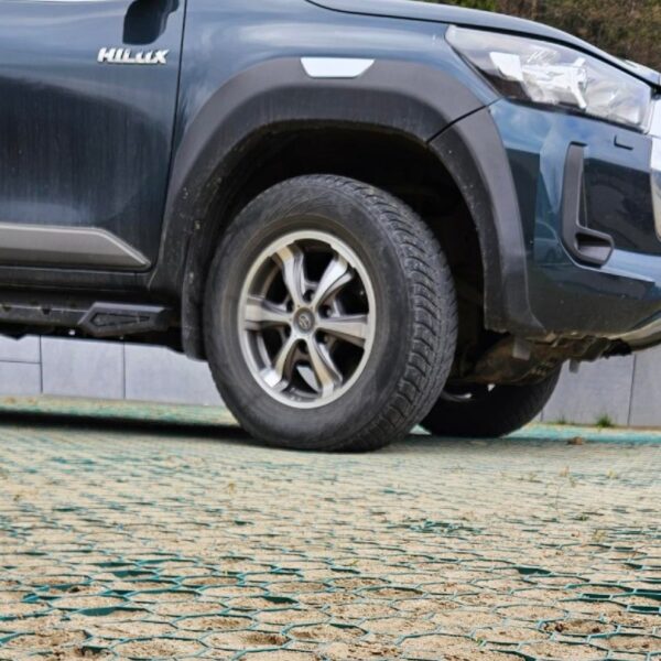 Zelená zatrávňovacia dlažba Multigravel pod kolesami SUV vozidla na spevnenom parkovisku